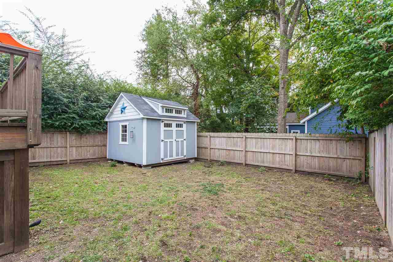 507 Adams Street Raleigh, NC 27605 - Photo 24 of 30 a view of a backyard with a small cabin and wooden fence