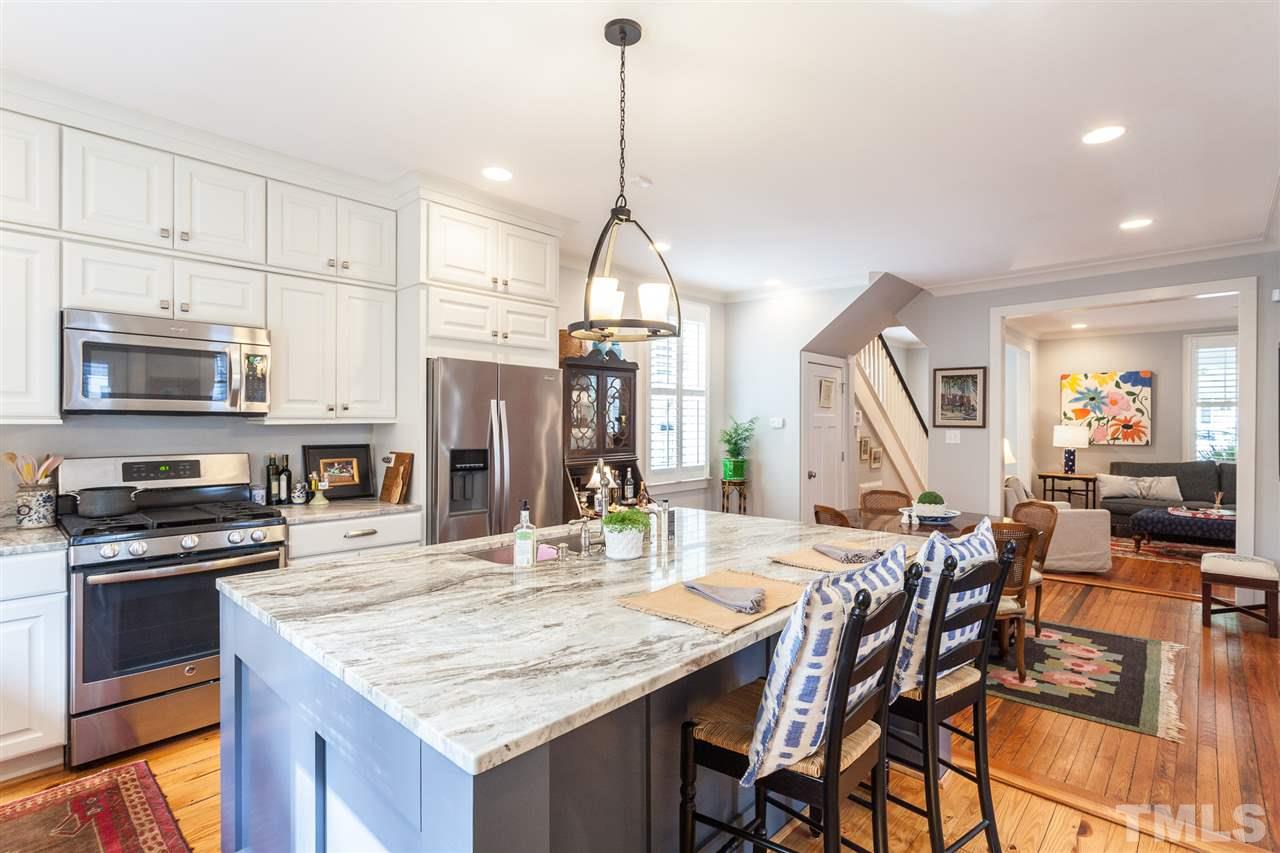 507 Adams Street Raleigh, NC 27605 - Photo 4 of 30 a kitchen with stainless steel appliances kitchen island granite countertop a kitchen island a stove a table and chairs