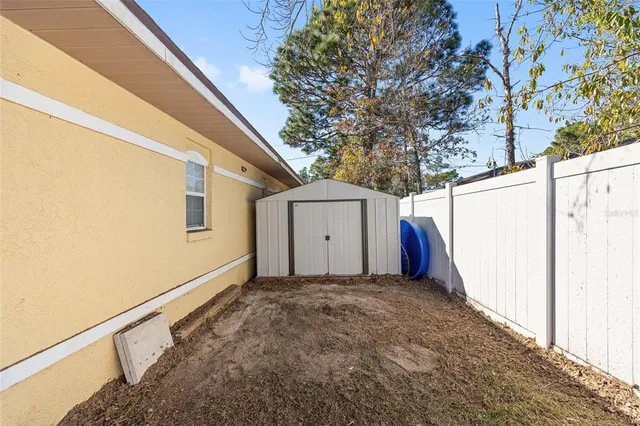 a view of a house with a large window and wooden fence