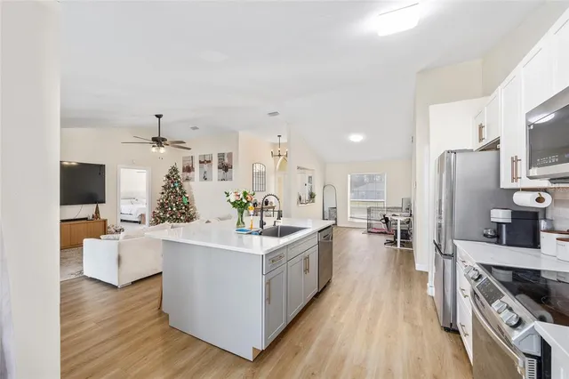 a large kitchen with stainless steel appliances a lot of counter space and wooden floor