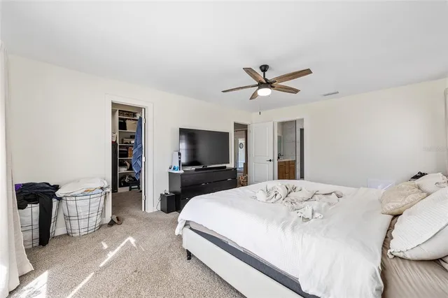 a bed room with a bed a television and a large window