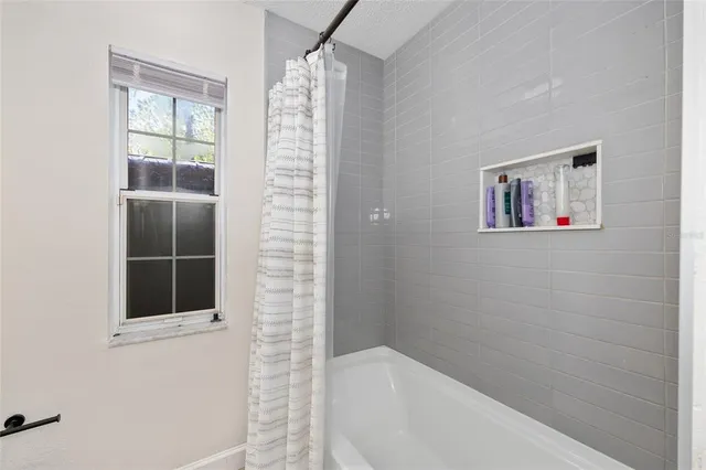 a bathroom with a bathtub and next to a window
