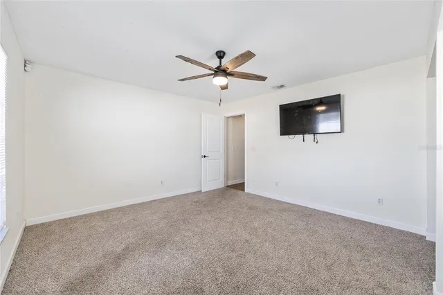 a view of a livingroom with a flat screen tv and a ceiling fan