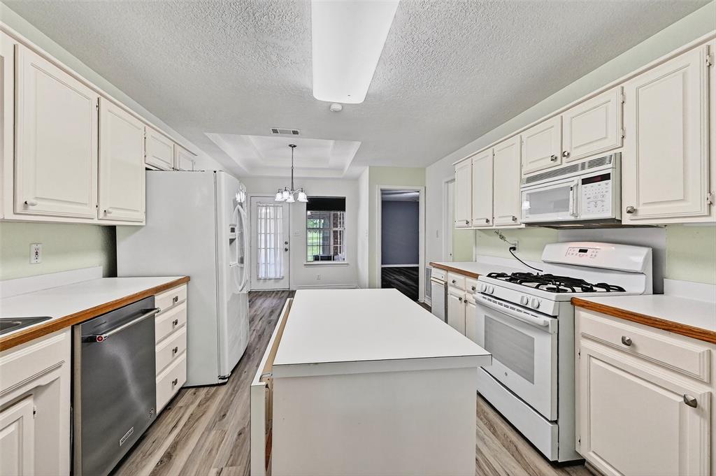 2107 Meadows Circle Sherman, TX 75092 - Photo 12 of 36 a kitchen with white cabinets and white appliances