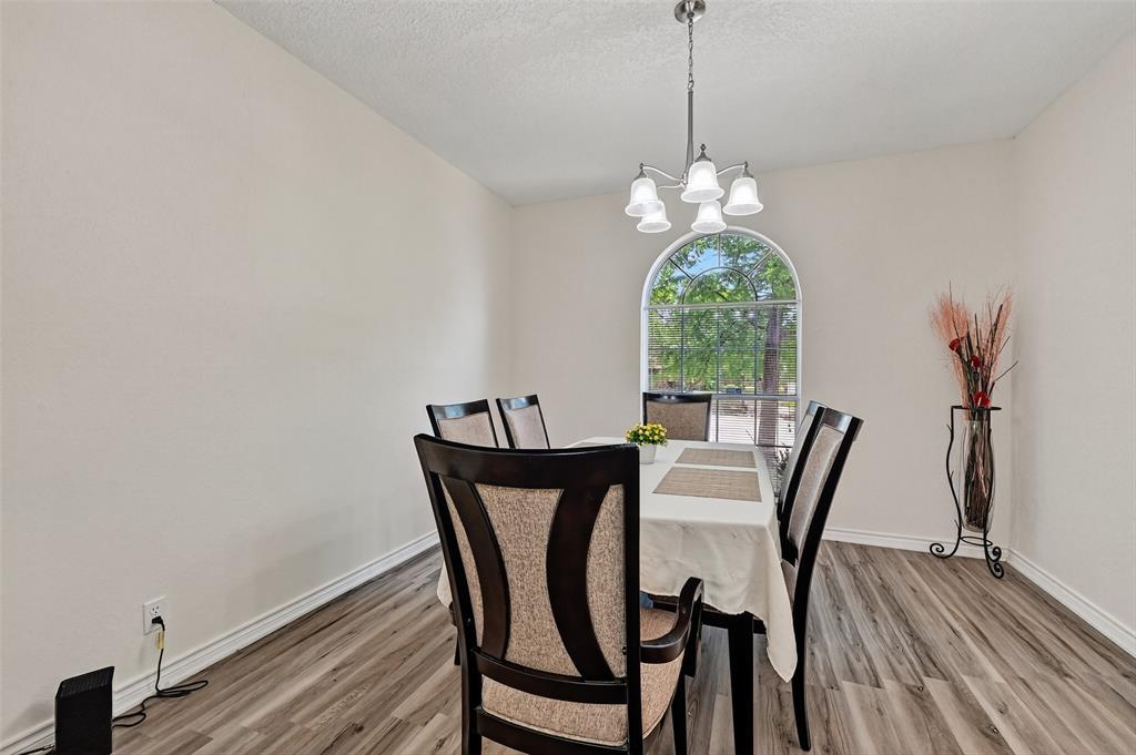 2107 Meadows Circle Sherman, TX 75092 - Photo 13 of 36 a dining room with furniture a chandelier and wooden floor