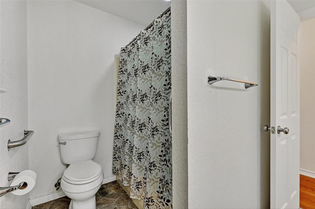 2107 Meadows Circle Sherman, TX 75092 - Photo 25 of 36 a white toilet sitting next to a shower curtain