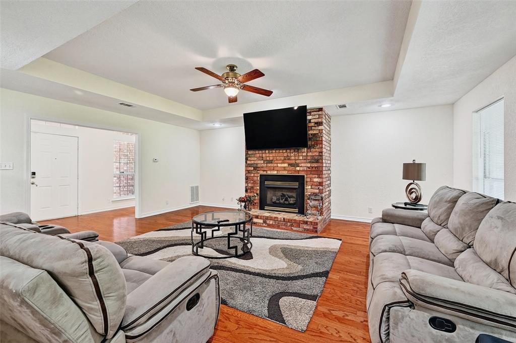 2107 Meadows Circle Sherman, TX 75092 - Photo 7 of 36 a living room with furniture a fireplace and a flat screen tv