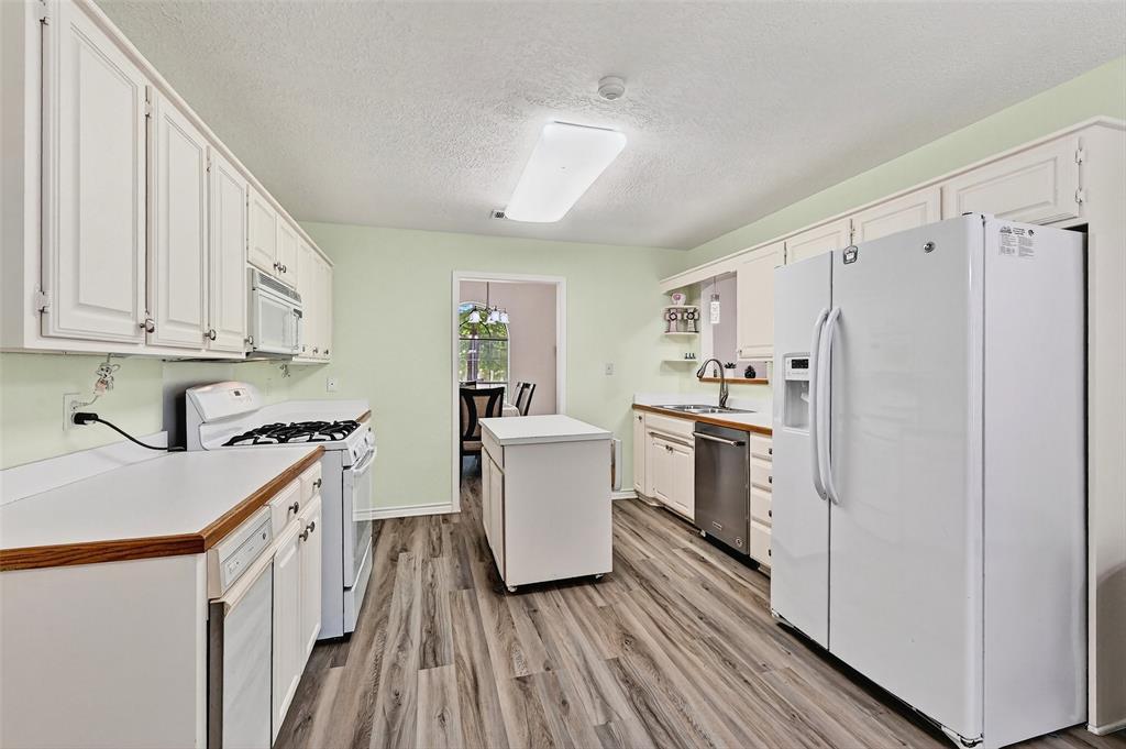 2107 Meadows Circle Sherman, TX 75092 - Photo 10 of 36 a kitchen with white cabinets and white appliances
