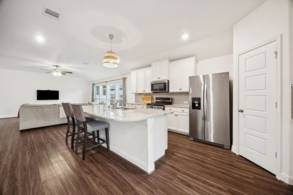 4431 Upland Stream Lane Katy, TX 77493 - Photo 5 of 17 a kitchen with stainless steel appliances a refrigerator a stove a sink dishwasher and a dining table with wooden floor