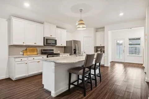 a view of kitchen with sink microwave and cabinets