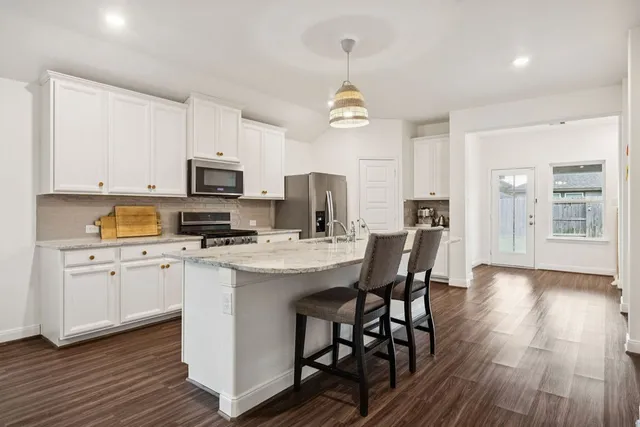 a view of kitchen with sink microwave and cabinets