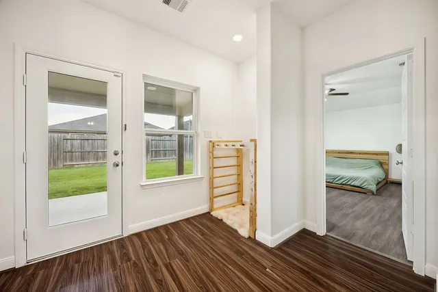 a view of a hallway with wooden floor and a living room