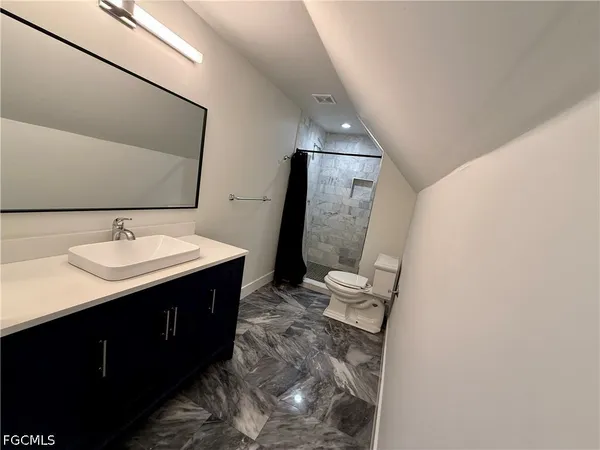 a bathroom with a sink vanity and mirror