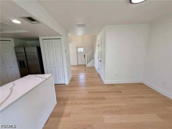 a view of a hallway with wooden floor and bathroom