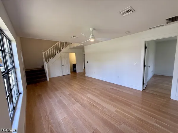 an empty room with wooden floor and a window