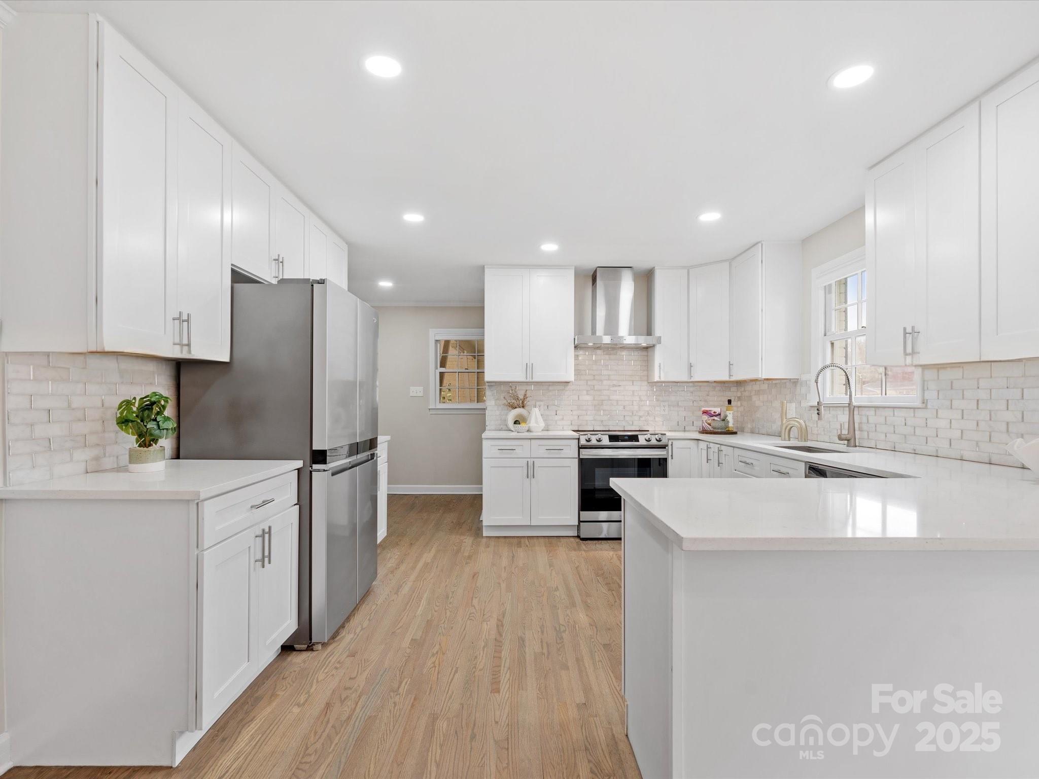122 Lansdowne Road Charlotte, NC 28270 - Photo 2 of 21 a kitchen with white cabinets stainless steel appliances and a sink