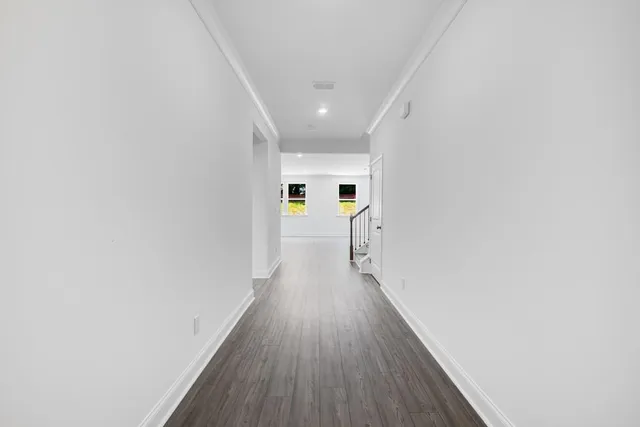 a view of an empty room with wooden floor