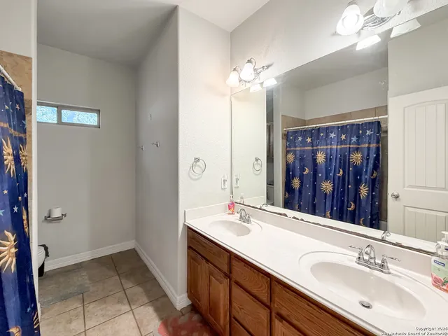 a bathroom with a double vanity sink and a mirror