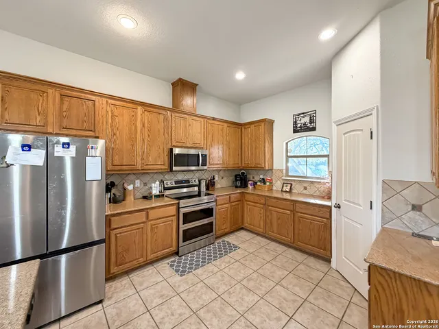 a kitchen with stainless steel appliances granite countertop a refrigerator sink and stove