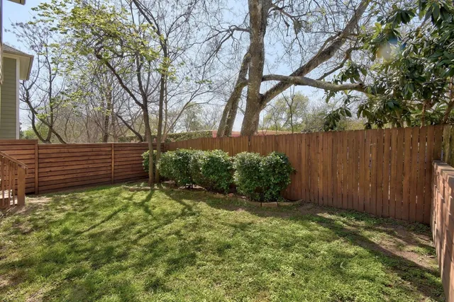 a view of garden with wooden fence