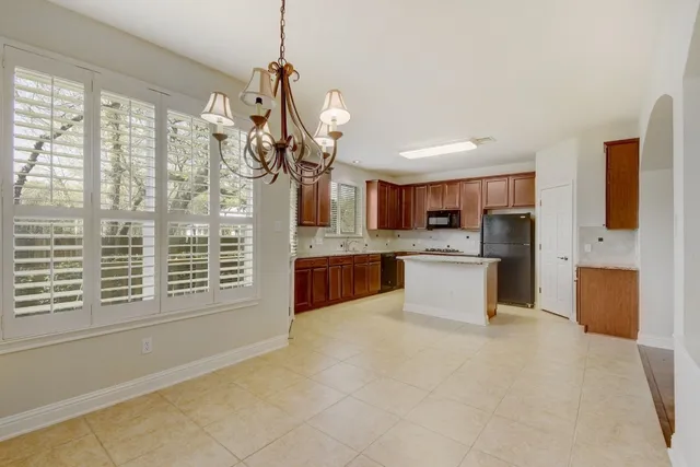 a large kitchen with a large counter top stainless steel appliances and cabinets