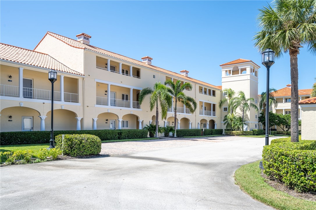 5060 Harmony Circle, Unit 304 Vero Beach, FL 32967 - Photo 1 of 36 a front view of a building with garden