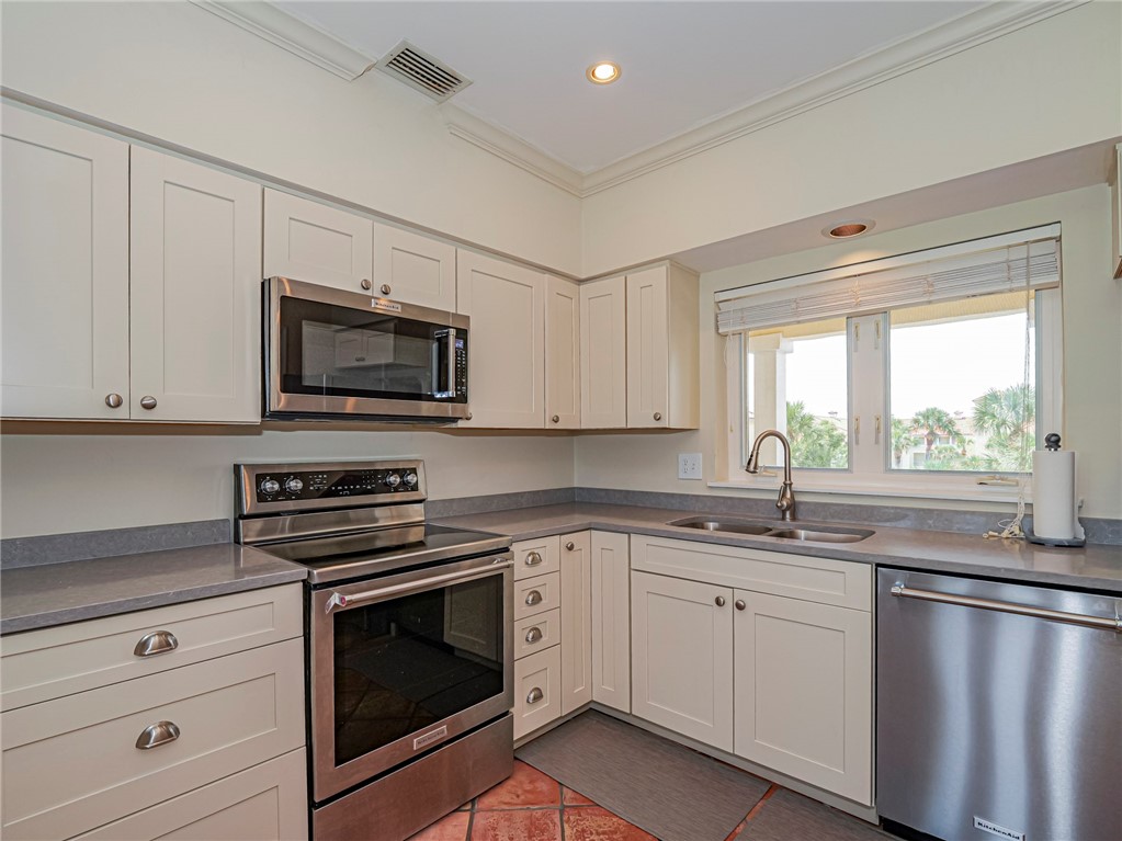5060 Harmony Circle, Unit 304 Vero Beach, FL 32967 - Photo 11 of 36 a kitchen with granite countertop a sink cabinets stainless steel appliances and a window