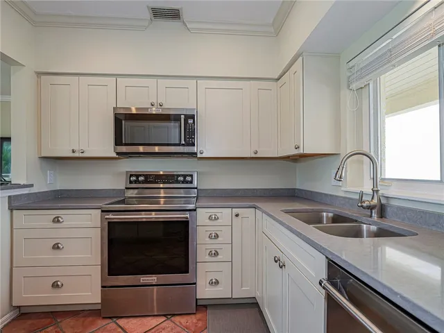 a kitchen with cabinets stainless steel appliances a sink and a microwave