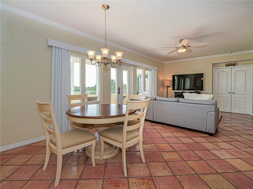 5060 Harmony Circle, Unit 304 Vero Beach, FL 32967 - Photo 16 of 36 a dining room with furniture a chandelier and kitchen view