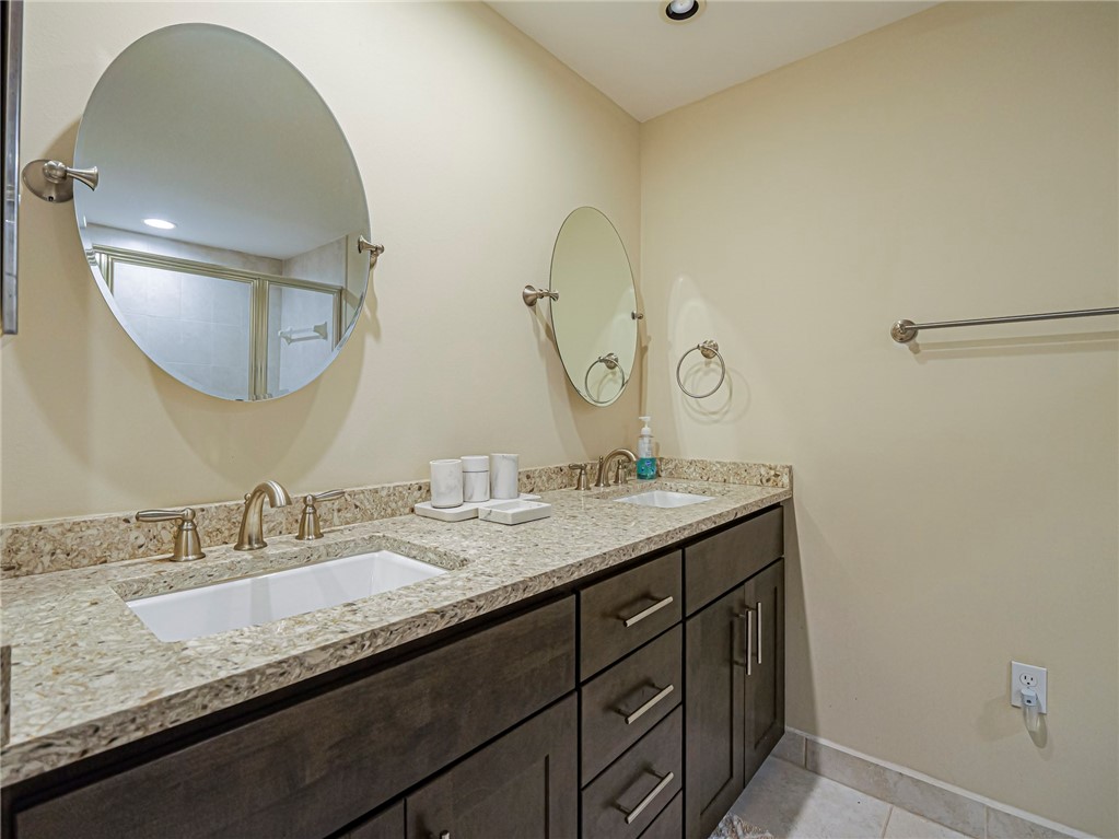 5060 Harmony Circle, Unit 304 Vero Beach, FL 32967 - Photo 22 of 36 a bathroom with a granite countertop double vanity sink and a mirror
