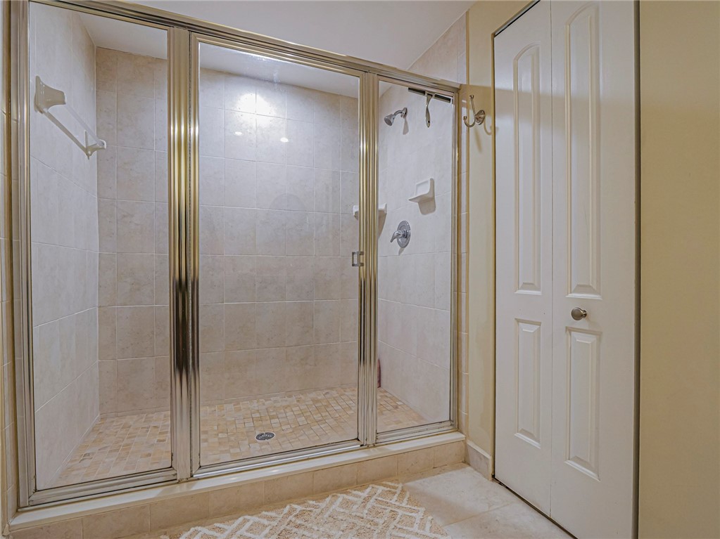 5060 Harmony Circle, Unit 304 Vero Beach, FL 32967 - Photo 23 of 36 a bathroom with a glass shower door