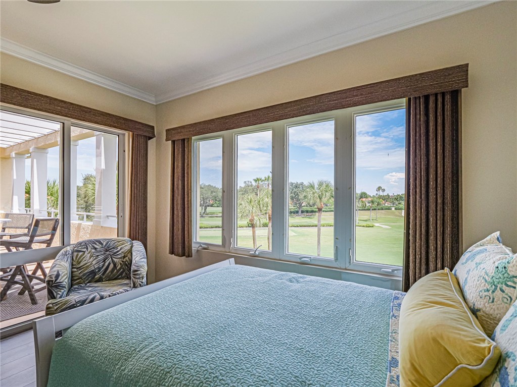5060 Harmony Circle, Unit 304 Vero Beach, FL 32967 - Photo 26 of 36 a spacious bedroom with a bed and glass windows