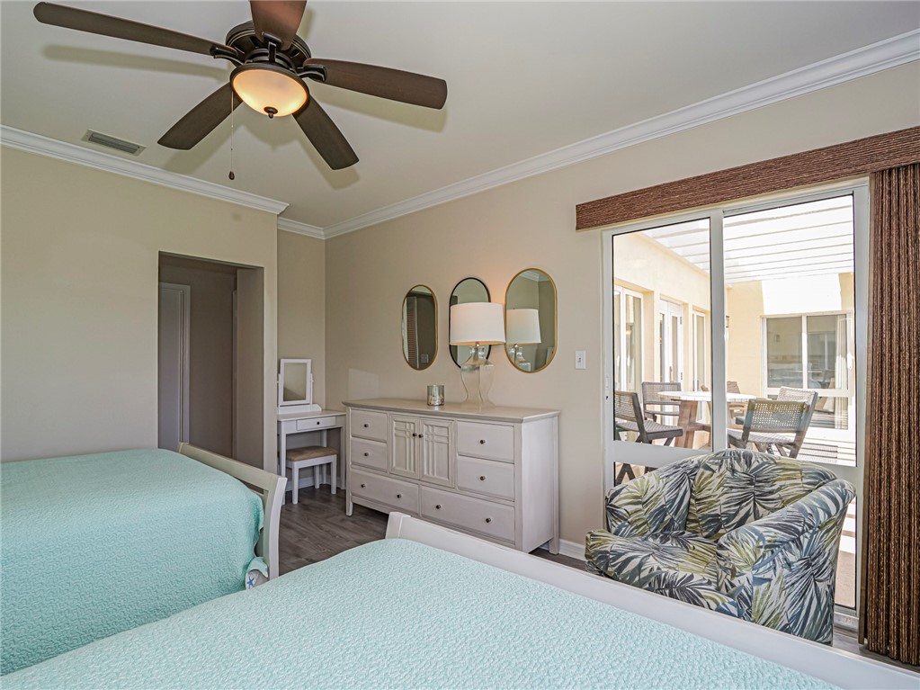5060 Harmony Circle, Unit 304 Vero Beach, FL 32967 - Photo 27 of 36 a bedroom with a bed and a chandelier
