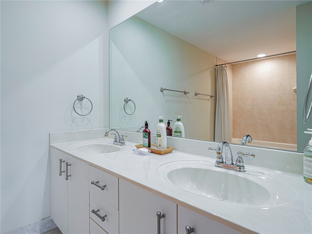 5060 Harmony Circle, Unit 304 Vero Beach, FL 32967 - Photo 28 of 36 a bathroom with double vanity sinks and a mirror