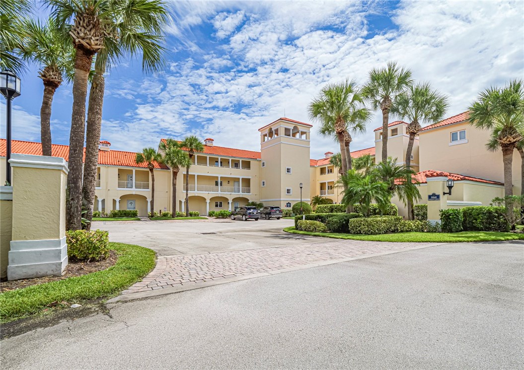 5060 Harmony Circle, Unit 304 Vero Beach, FL 32967 - Photo 3 of 36 a front view of a house with a yard and garage