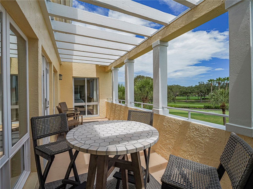 5060 Harmony Circle, Unit 304 Vero Beach, FL 32967 - Photo 33 of 36 a view of an outdoor dining space with a table and chairs