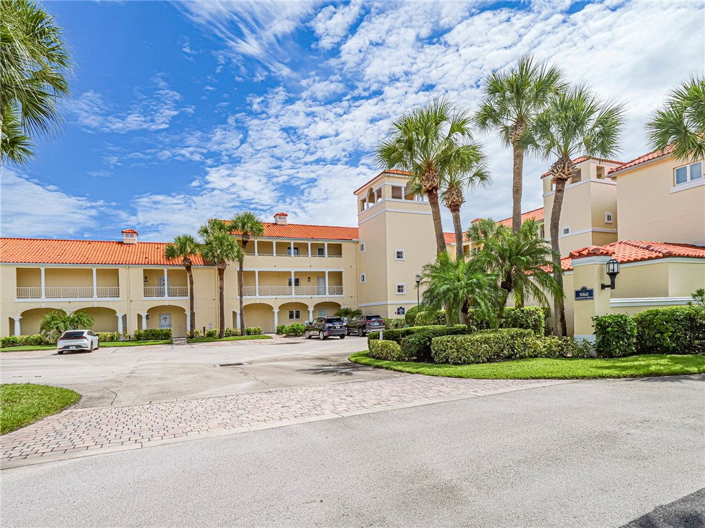5060 Harmony Circle, Unit 304 Vero Beach, FL 32967 - Photo 4 of 36 a city street lined with buildings and trees