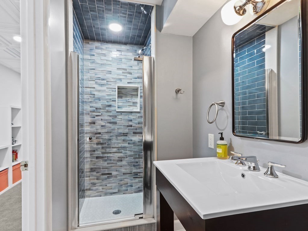 53 Marshall Street Newton, MA 02459 - Photo 36 of 42 a bathroom with a sink a mirror and shower