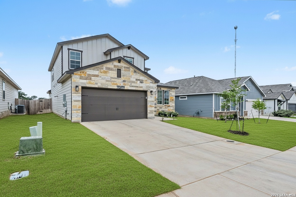 16515 Rosemary Ridge Elmendorf, TX 78112 - Photo 2 of 27 a front view of a house with a yard and garage