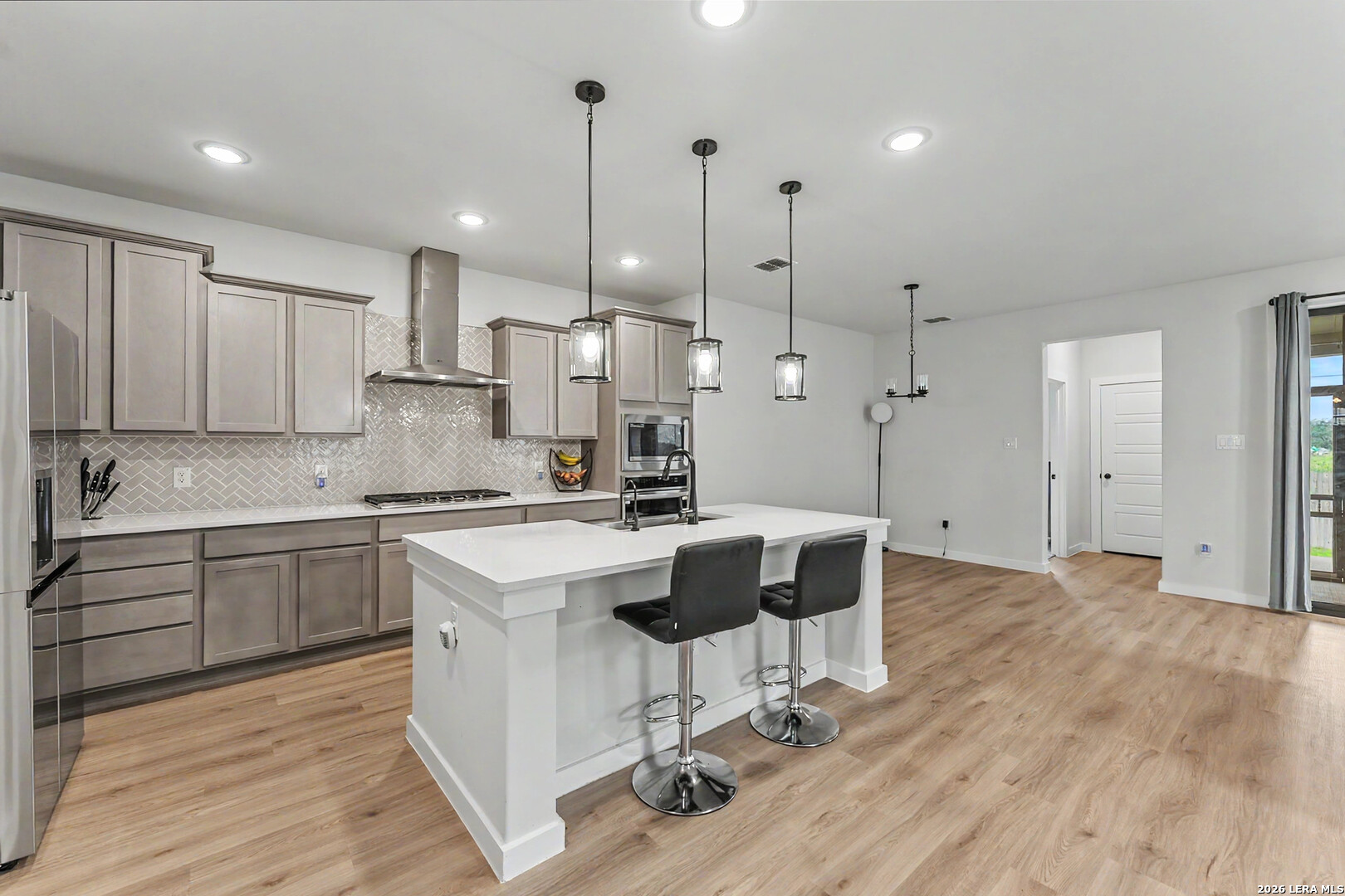 16515 Rosemary Ridge Elmendorf, TX 78112 - Photo 4 of 27 a kitchen with kitchen island granite countertop a sink a counter space and appliances