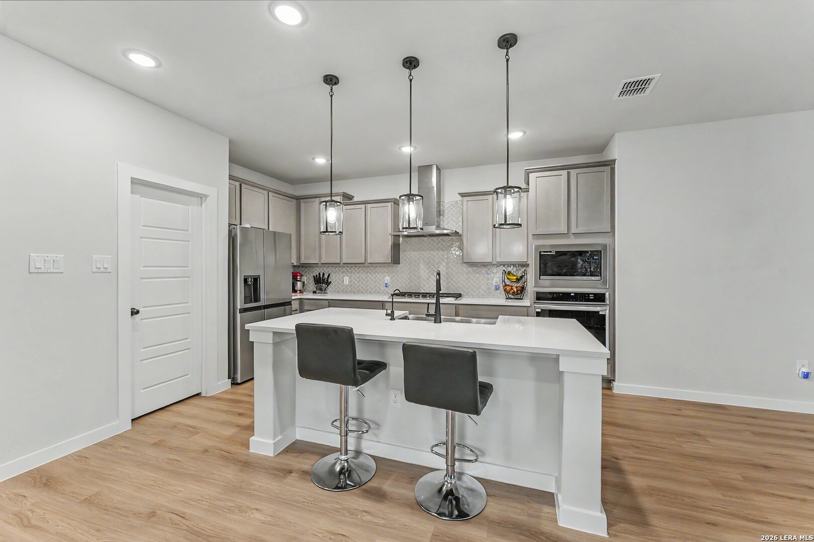 16515 Rosemary Ridge Elmendorf, TX 78112 - Photo 5 of 27 a kitchen with stainless steel appliances granite countertop a sink a stove a refrigerator and island with wooden floor