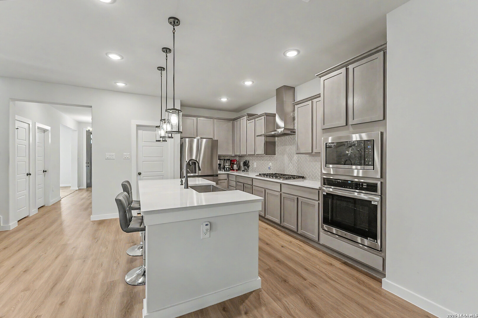 16515 Rosemary Ridge Elmendorf, TX 78112 - Photo 6 of 27 a kitchen with kitchen island white cabinets and stainless steel appliances