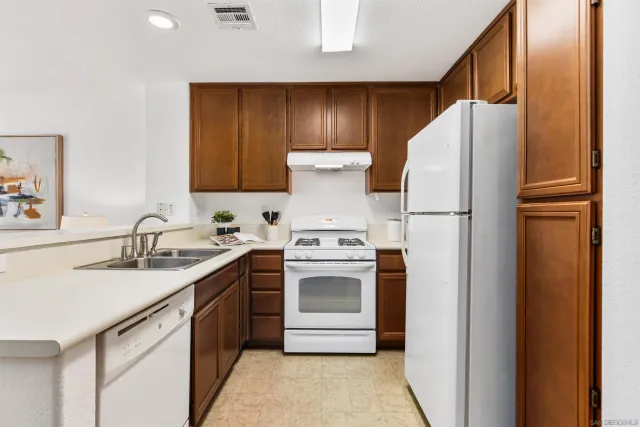 a kitchen with a white refrigerator and a sink