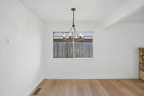 a view of a room with wooden floor projector and a window