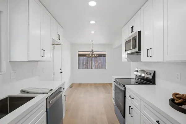 a kitchen with stainless steel appliances a sink stove and cabinets