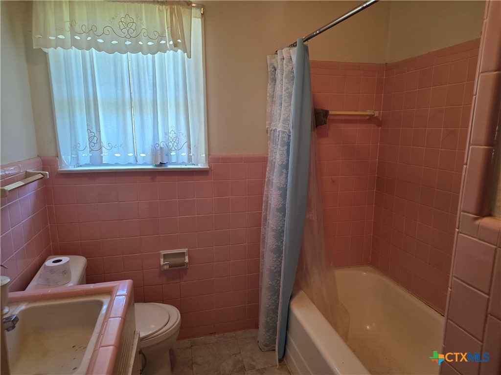 1903 South 13th Street Temple, TX 76504 - Photo 13 of 18 a bathroom with a sink a toilet a bathtub and shower