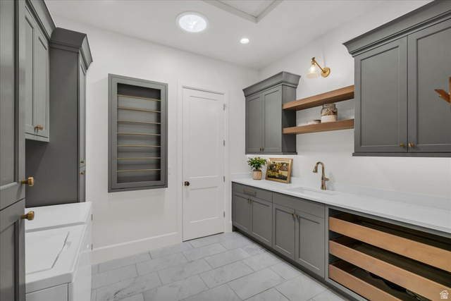 2608 Canyon Ridge Drive St. George, UT 84770 - Photo 41 of 86 Spacious laundry room featuring extensive built-in cabinetry, durable tile flooring, a large sink basin with a gooseneck faucet, integrated drying racks, and recessed lighting