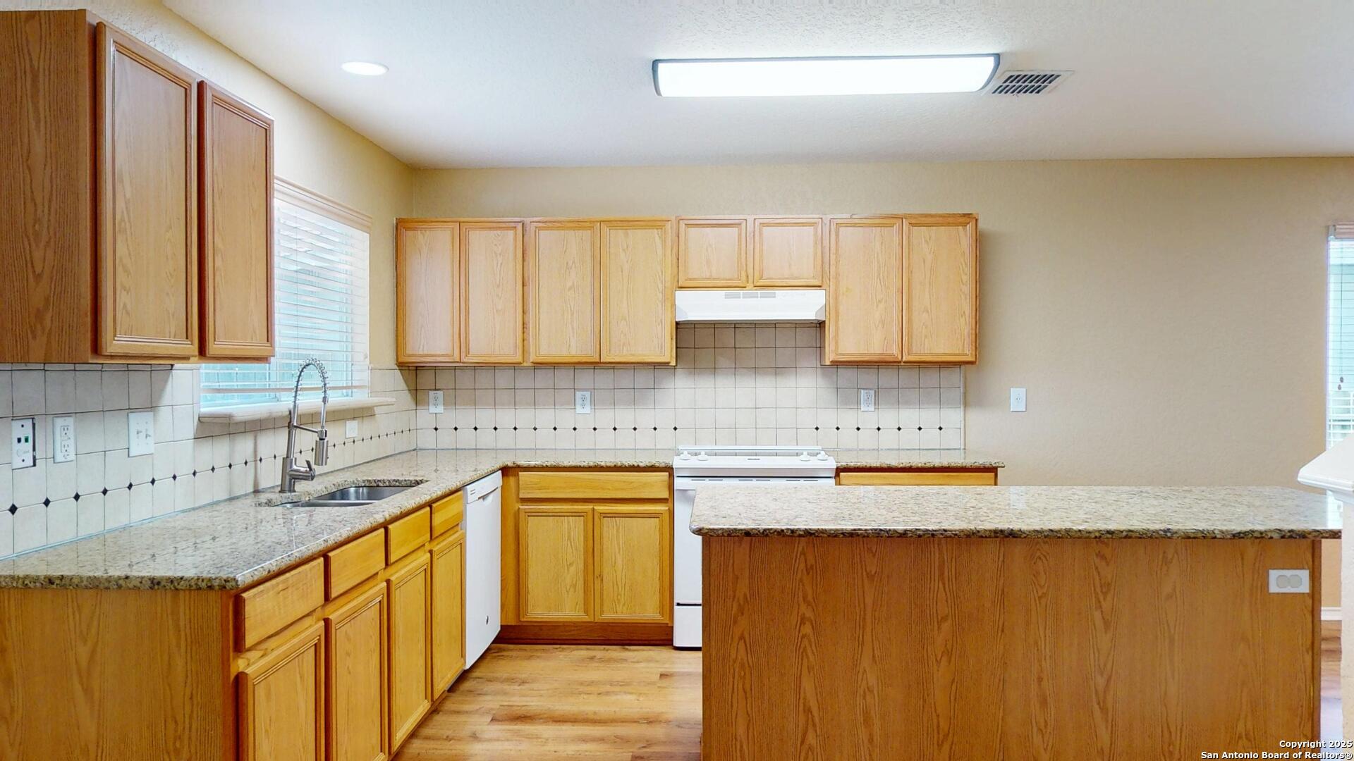 117 Foxglove Pass Cibolo, TX 78108 - Photo 12 of 46 a kitchen with stainless steel appliances granite countertop a sink stove and cabinets