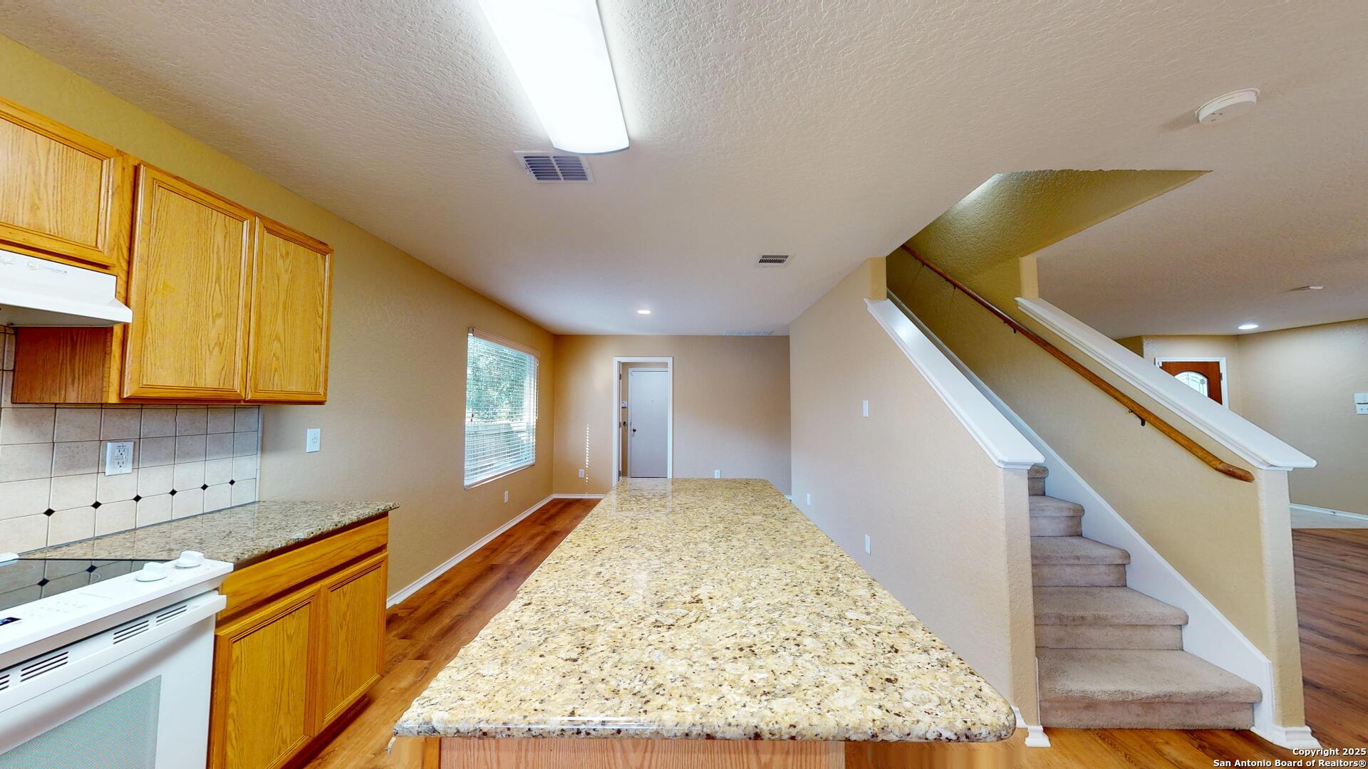 117 Foxglove Pass Cibolo, TX 78108 - Photo 13 of 46 a view of a kitchen with wooden floor and staircase