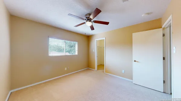 a view of an empty room with a ceiling fan